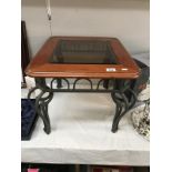 A wrought iron coffee table with bevelled glass top