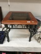 A wrought iron coffee table with bevelled glass top