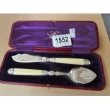A cased butterknife and cheese scoop.