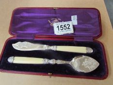 A cased butterknife and cheese scoop.