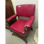 A 19th century oak framed armchair with hooped legs and red leather upholstery.