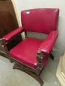 A 19th century oak framed armchair with hooped legs and red leather upholstery.