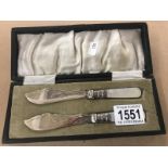 A cased pair of silver plated butter knives with mother of pearl handles.
