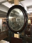 An oval framed bevel edged mirror.