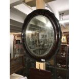 An oval framed bevel edged mirror.