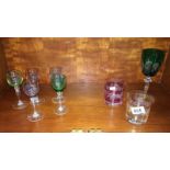 A small collection of etched & coloured glass drinking glasses