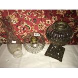 A metal oil lamp base with glass drop in font, another glass oil lamp font and an oil lamp chimney.