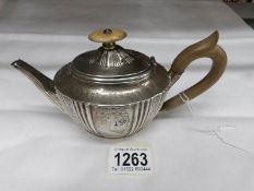 A small silver tea pot.