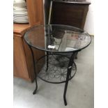 A wrought iron side table with bevel glass top