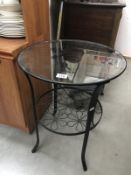 A wrought iron side table with bevel glass top