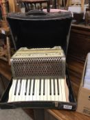 A cased Hohner piano accordion.