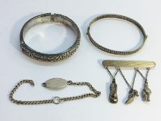 A Chinese silver bracelet, silver charm brooch,