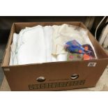 A box of linen including table cloths etc.