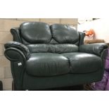 A green leather 2 seater sofa
