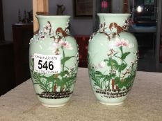 A pair of green decorated ceramic vases - bird & relief - cast flowers