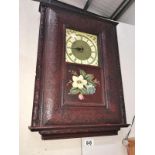 A carved wood framed wall clock with painted flower panel (Roman numeral clock face)