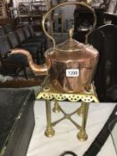 A Victorian copper kettle and a Victorian brass trivet.