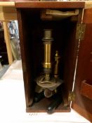 A Victorian wood cased brass microscope.
