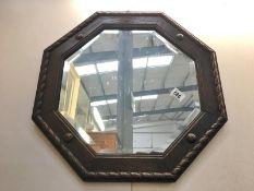 An octagonal bevel edged mirror with carved wood frame