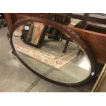 An oval bevel edged mirror in mahogany frame.