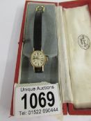 A ladies gold Tissot wrist watch on a leather strap, in working order.