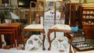 A pair of wood chairs with floral upholstered seats