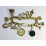 A gold charm bracelet including 13 gold charms etc.