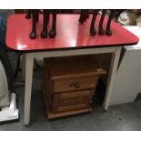 A red formica-top retro kitchen table with casters