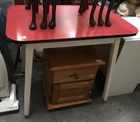 A red formica-top retro kitchen table with casters