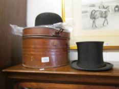 A collapsible top hat in vintage tin case and a Dunn & Co., bowler hat.