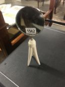 A magnifying glass on tripod base.