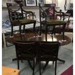 A dark wood stained extending dining table on brass lion paw/feet castors & string inlay to top,