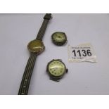 A vintage gold wrist watch in working order, a silver watch head and another old watch head.