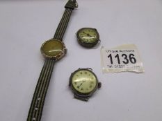 A vintage gold wrist watch in working order, a silver watch head and another old watch head.