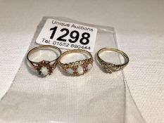 3 gold rings (all hall marked but one worn) set with various stones including opal and rubies.