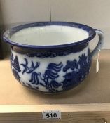 A blue and white willow pattern chamber pot.