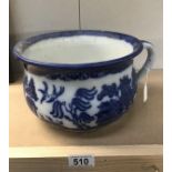 A blue and white willow pattern chamber pot.
