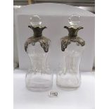 A pair of 19th century glass decanters with metal mounts.