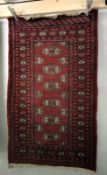 A small red patterned Eastern rug approximately 160cm x 95.
