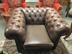 A brown leather Chesterfield chair.