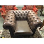 A brown leather Chesterfield chair.