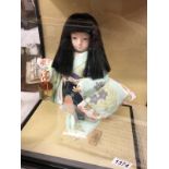 A cased Japanese 'Ichimatsu' Gotun doll with glass eyes.