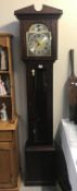 A modern dark wood stained tempus fugit grandfather clock.