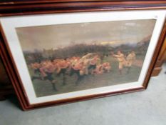 A large framed and glazed print of an early rugby scene.