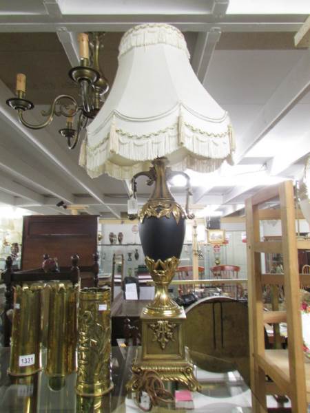 An urn shaped table lamp with gilding and complete with shade.