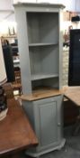 A shabby chic painted corner cupboard.