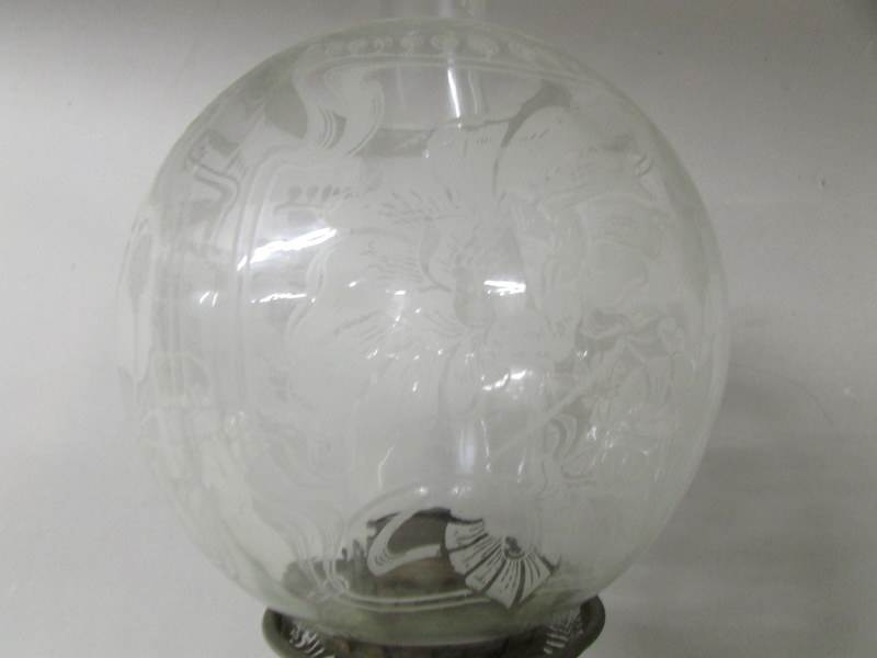A Victorian oil lamp with clear glass font and floral acid etched shade on a cast iron base. - Image 4 of 4