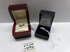 A cushion cubic zirconia gold plated dress ring (size K half) and a cubic zirconia trilogy ring in