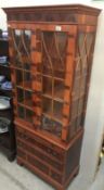 A wooden cabinet with astragal glazed doors.