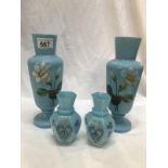 A pair of hand painted blue glass vases and a smaller pair.